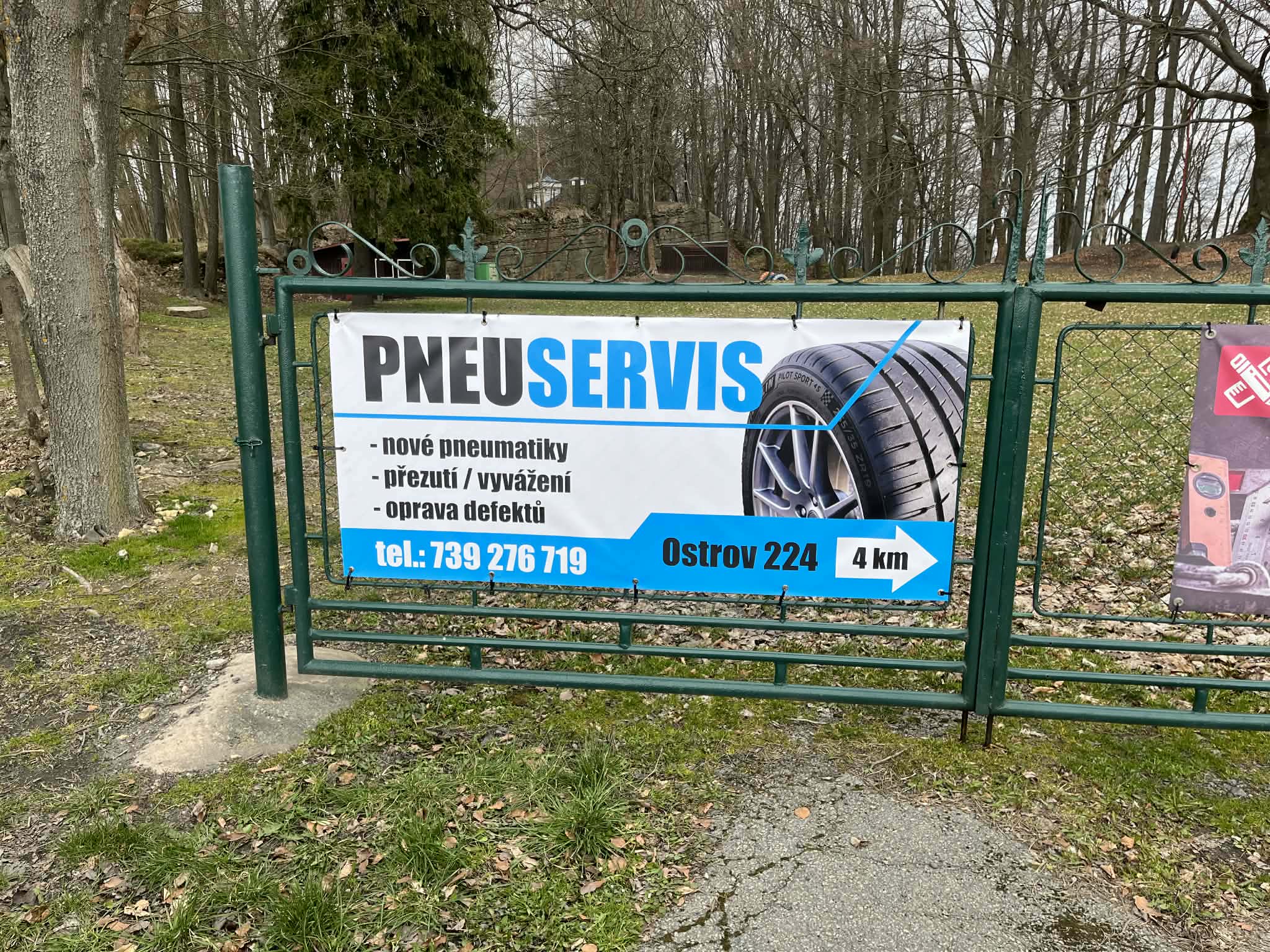 Cedule pneuservisu u hlavní silnice v Ostrově